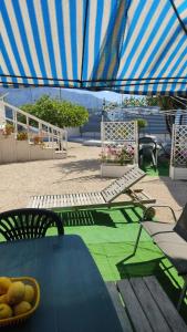 a patio with a table and a blue umbrella at Green Garden da Virna 2 in Torre Annunziata