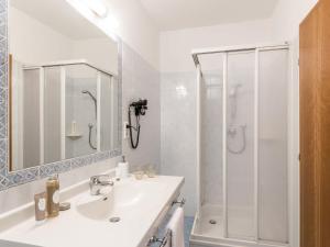 a white bathroom with a sink and a shower at Apartment Pienzenau by Interhome in Postal