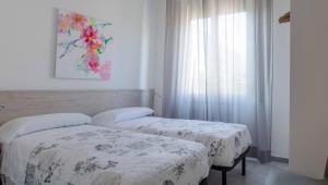 En eller flere senge i et værelse på Veraloano Apartments
