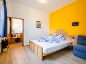 a bedroom with a bed and a blue chair at Apartment Rosengartenhof-5 by Interhome in Andrian