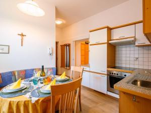a kitchen with a table and chairs in a room at Apartment Rosengartenhof-5 by Interhome in Andrian
