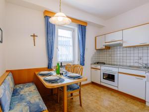 a kitchen with a table and a dining room at Apartment Rosengartenhof-1 by Interhome in Andrian