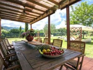 a bowl of fruit on a wooden table on a patio at Holiday Home Daussiè by Interhome in Castelvecchio