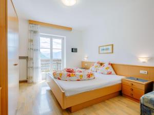 a bedroom with a bed and a window at Apartment Rosengartenhof-1 by Interhome in Andrian