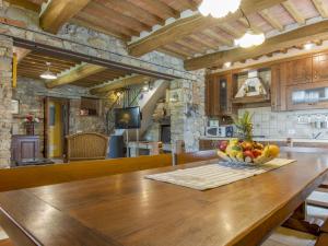 a kitchen with a table with a bowl of fruit on it at Holiday Home Daussiè by Interhome in Castelvecchio