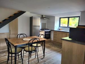 a kitchen with a table and chairs in a kitchen at La Renardiere in Le Vigan