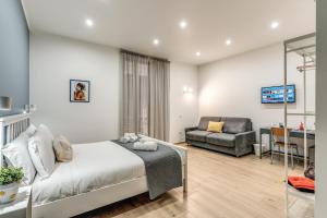 una camera con letto, divano e scrivania di Caravita Rooms a Napoli
