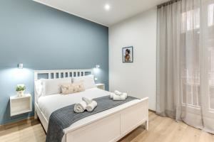 una camera da letto con un letto bianco con asciugamani sopra di Caravita Rooms a Napoli