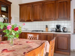 a kitchen with a table with a vase of roses on it at Holiday Home Antica Cascina by Interhome in Castagnole Lanze