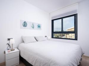 a bedroom with a white bed and a window at Apartment Cala Mora by Interhome in Moraira