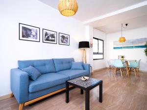 a living room with a blue couch and a table at Apartment Cala Mora by Interhome in Moraira