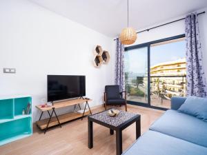 a living room with a blue couch and a table at Apartment Cala Mora by Interhome in Moraira
