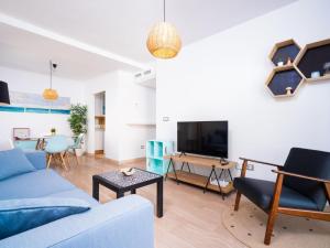 a living room with a blue couch and a table at Apartment Cala Mora by Interhome in Moraira +15 photos