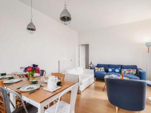 a living room with a table and a blue couch at Holiday Home La Floriette by Interhome in Dinard