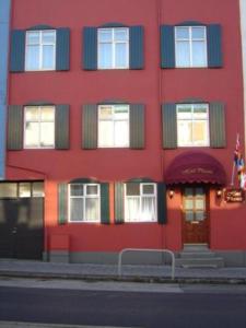 a red building on the side of a street at Hotel Phoenix in Reykjavík