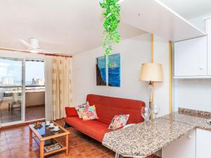 Una sala de estar con un sofá rojo y una mesa. en Apartment Bonaire III by Interhome, en Oropesa del Mar 16 fotos más