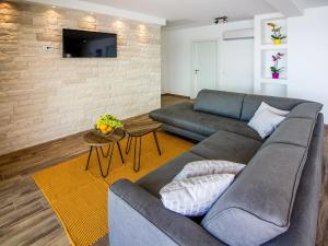 sala de estar con sofá y TV en una pared de ladrillo en Villa Vista sul Quarnero by Interhome, en Matulji
