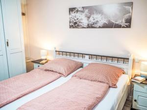 レーベルにあるApartment Müritz Ferienpark Röbel-54 by Interhomeのベッドルーム1室(ピンクの枕が付くベッド2台付)