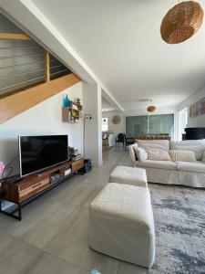 a living room with two couches and a flat screen tv at Maison à louer au pays basque in Anglet