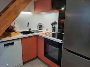 a small kitchen with a stove and a refrigerator at La Marmotte in La Bastide