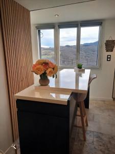a vase of flowers sitting on a desk in front of a window at La Marmotte in La Bastide +7 photos