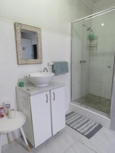 a white bathroom with a sink and a shower at Destiny Jeffreys bay in Jeffreys Bay +41 photos