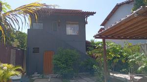 a black house with a brown door in a yard at Vila Floresta - Arraial D'Ajuda in Porto Seguro