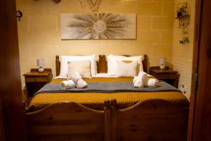 a bedroom with a large bed with white pillows at Il figolla farmhouse in Xagħra