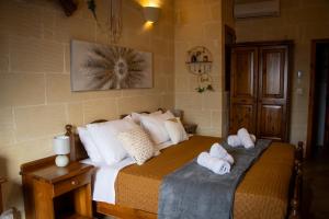 a bedroom with a bed with towels on it at Il figolla farmhouse in Xagħra
