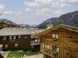 a group of wooden buildings with mountains in the background at Apartment Stabler by Interhome in Pera