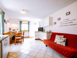 a living room with a red couch and a kitchen at Apartment Stabler by Interhome in Pera
