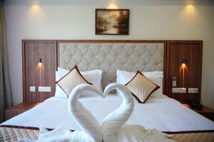 two swans making a heart shape on a bed at Tranquil Riverview Inn in Kottayam +23 photos