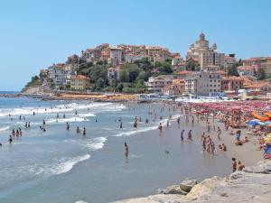 a crowd of people on a beach with buildings at Holiday Home Villetta Paola - IMP232 by Interhome in Caramagna Ligure