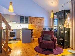 a living room with a chair and a kitchen at Holiday Home Katinkulma 2 by Interhome in Vuokatti +26 photos