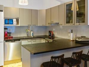 a kitchen with white cabinets and a black counter top at Holiday Home Katinkulma 2 by Interhome in Vuokatti