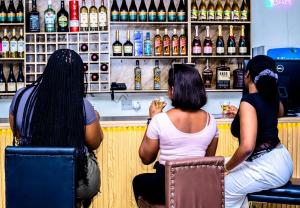 a group of three women sitting at a bar at Ja'Oak Hotel and Suites in Benin City