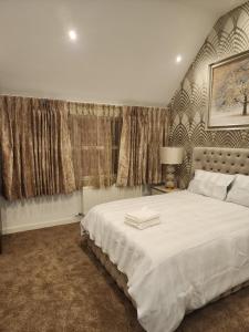 a bedroom with a large white bed and curtains at CITY CENTRE LUXURY House WITH THREE VERY LARGE SIZE BEDROOMS in Belfast