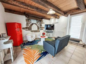 sala de estar con sofá azul y armario rojo en Holiday Home La Fée Margot by Interhome, en Le Gouray