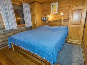 萨拉Holiday Home Kelomaja 12b by Interhome的一间位于木制客房内的卧室,配有一张蓝色的床 更多7张照片