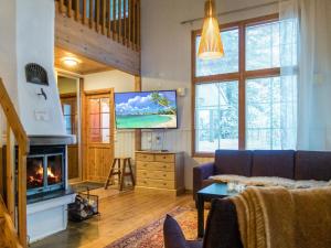 a living room with a fireplace and a tv at Holiday Home Katinkulma 1 by Interhome in Vuokatti