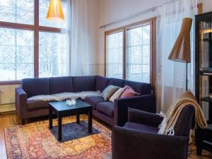 a living room with a blue couch and a table at Holiday Home Katinkulma 1 by Interhome in Vuokatti