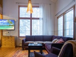 a living room with a purple couch and a tv at Holiday Home Katinkulma 1 by Interhome in Vuokatti +26 photos