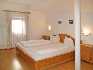 a bedroom with a large bed with white sheets at Apartment Nebenhaus Schönblick - SVH112 by Interhome in San Valentino alla Muta