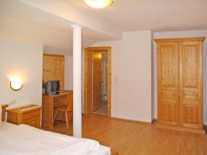 a bedroom with a bed and a desk with a television at Apartment Nebenhaus Schönblick - SVH112 by Interhome in San Valentino alla Muta