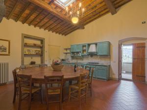 a large kitchen with a wooden table and chairs at Holiday Home Reggine-3 by Interhome in Panzano