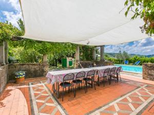 a table and chairs under a tent next to a pool at Holiday Home Reggine-3 by Interhome in Panzano