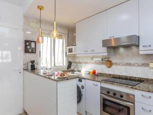 a white kitchen with white cabinets and a sink at Apartment Portofino IV by Interhome in Oropesa del Mar