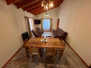 a living room with a wooden table and chairs at Hosteria Yamile in El Calafate