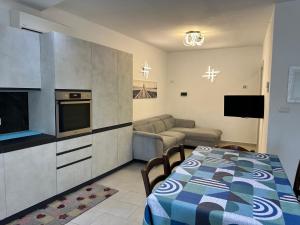 a kitchen and living room with a table and a couch at Beautiful Apartment with Swimming Pool in Olbia