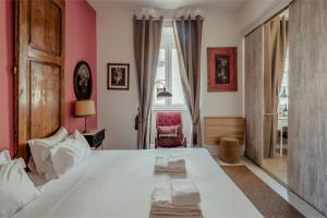 Un dormitorio con una gran cama blanca y una silla. en Labor Alliance Residence by LovelyStay, en Lisboa